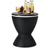 Zwarte bijzettafel met rotanlook, met glazen blad met drankjes, waaronder flessen bier en een glas sap.