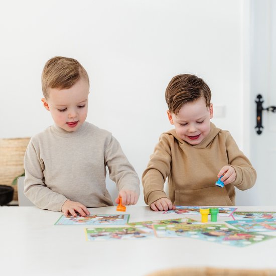 Twee jonge jongens spelen met de Fien & Teun stempelset. Eén jongen gebruikt een oranje stempel, de andere houdt een blauwe stempel vast.