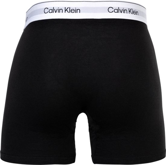 Achterkant van zwarte Calvin Klein boxer briefs met witte tailleband met logo.