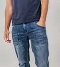 Detail van een stonewashed blauwe jeans met opgestikte zakken met extra stiksels op de voorkant.