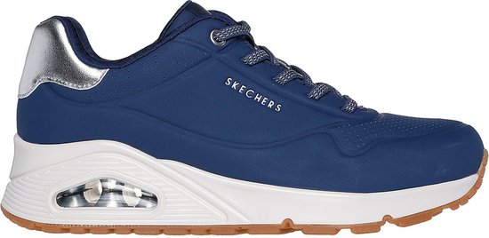 Zijaanzicht van de donkerblauwe Skechers sneaker met contrasterende witte zool en bruin profiel.