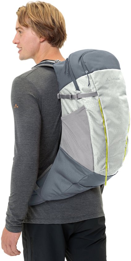 Man met grijze Vaude rugzak, met lichtgrijs voorpaneel met geometrisch patroon en gele accenten.