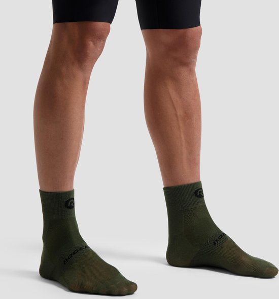 Legergroene fietssokken met 'R' logo op de schacht en 'ROGELI' op de voet, gedragen door een model.