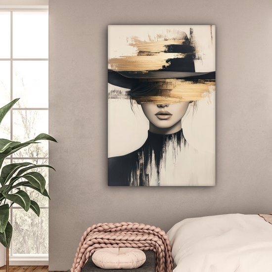 Abstract portret van een vrouw met zwarte hoed en gouden verfstreken, hangend boven een bed in een slaapkamer.