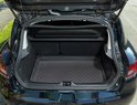 Tapis de coffre noir à motif diamant dans le coffre ouvert d'une voiture.