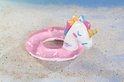 Roze glitter zwemband in eenhoornvorm op het strand.