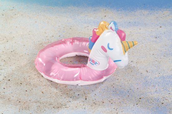 Roze glitter zwemband in eenhoornvorm op het strand.
