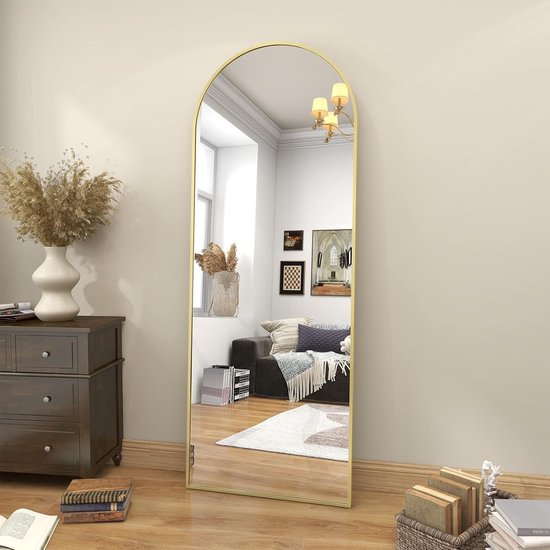 Miroir arche debout à cadre doré, reflétant un salon avec cheminée.