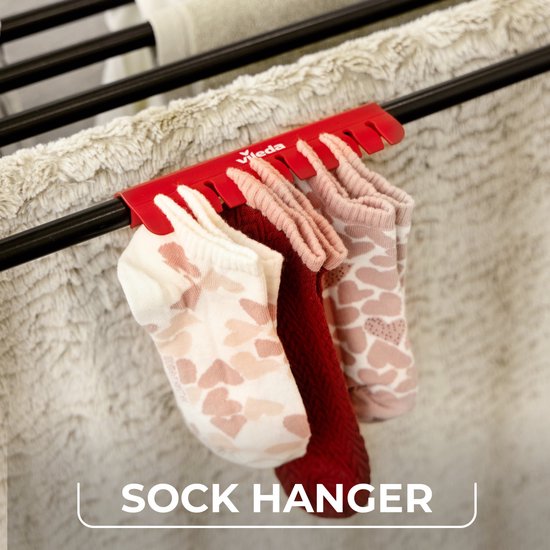 Close-up van sokken die aan de rode "sock hanger" van het Vileda Infinity Flex droogrek hangen.