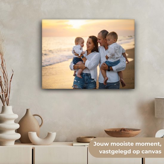 Familie op het strand bij zonsondergang