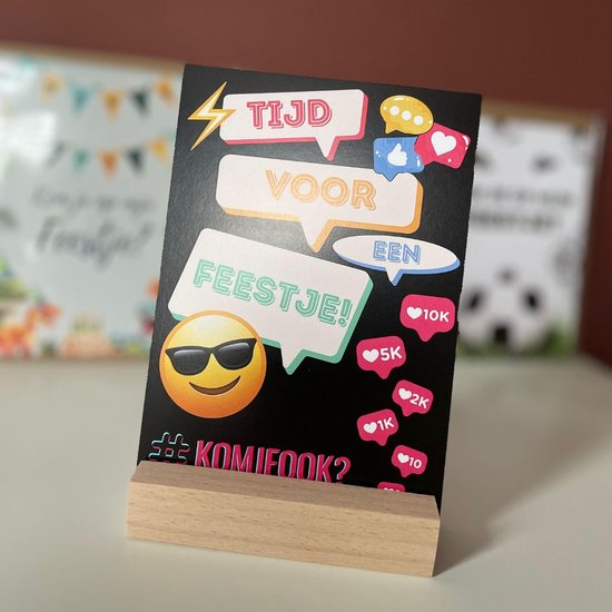 Zwarte uitnodigingskaart op een houten standaard. Tekstballonnen 'Tijd voor een feestje!' met emoji.