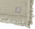 Groene deken van mousseline met rafels en een label 'Jollein'.