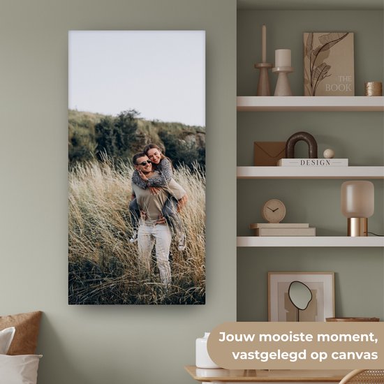 Een man met een vrouw op zijn rug, lachend in een veld.