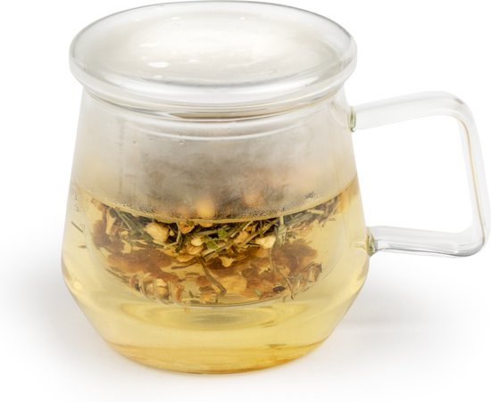 Mug à thé en verre avec un couvercle transparent, rempli de thé jaune et d'herbes dans un filtre à thé argenté.