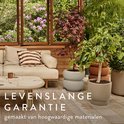 Een bank en een tafel op een terras, met twee lichtbruine plantenbakken met gestapeld design en een bruine plantenbak.