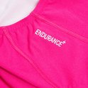 Gedetailleerde close-up van een felroze sportbadpak met de tekst 'ENDURANCE+' geborduurd.