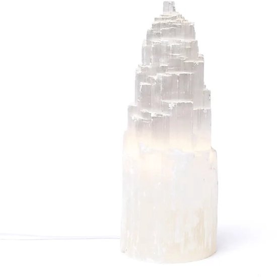 Hoge, trapsgewijze witte selenietlamp met een geëtste textuur, verlicht van binnenuit met een witte gloed.