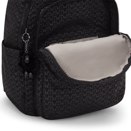 Open voorvak van een zwarte Kipling rugzak met patroon en Kipling aapje.