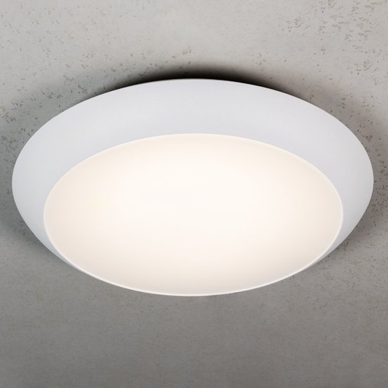 Moderne, witte ronde LED-plafondlamp gemonteerd aan een betonnen plafond.
