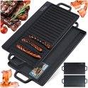Zwarte gietijzeren grillplaat met ribbels, met worstjes en een platte kant, met gegrild vlees en spek ernaast.