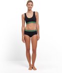 Model in zwarte sport-bh met groene band en zwarte boyshorts.