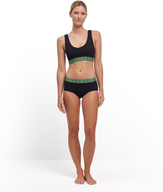 Model in zwarte sport-bh met groene band en zwarte boyshorts.
