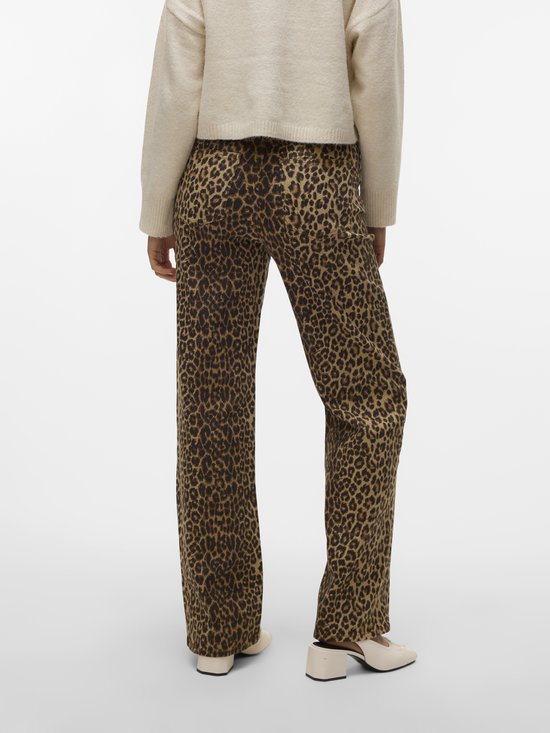 Model in beige trui en broek met luipaardprint, zijaanzicht.