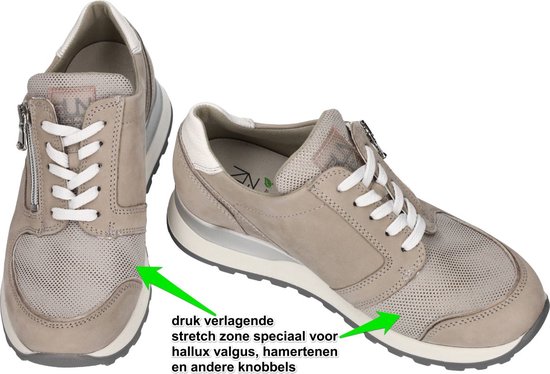 Twee grijze sneakers met rits en witte veters. Pijlen wijzen op drukontlastende stretch zone voor de voorvoet.