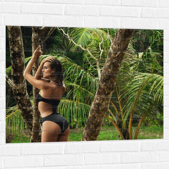 Muursticker - Poserende Vrouw in Zwarte Bikini bij Palmboom - 100x75 cm Foto op Muursticker