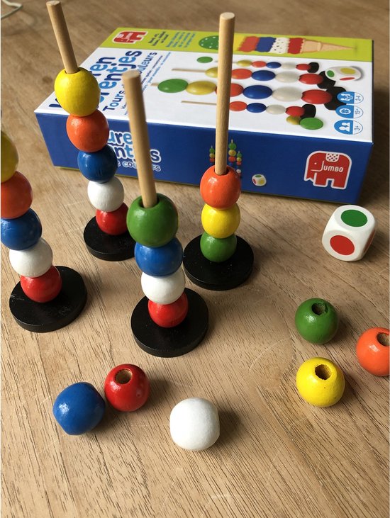 Close-up van het spel Kleurentorentjes met opgestapelde torentjes, losse kralen en een dobbelsteen.