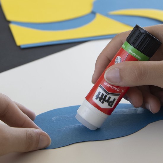 Hand met Pritt lijmstift brengt lijm aan op blauw papier.