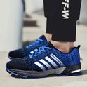 Blauwe hardloopschoenen met zilveren strepen en 'keep running' opdruk, gedragen door een persoon.