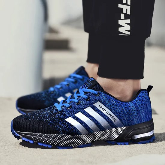 Blauwe hardloopschoenen met zilveren strepen en 'keep running' opdruk, gedragen door een persoon.