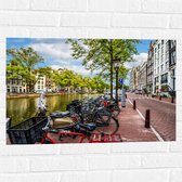 Muursticker - Rij Fiets Geparkeerd langs de Gracht in Amsterdam - 75x50 cm Foto op Muursticker