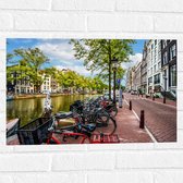 Muursticker - Rij Fiets Geparkeerd langs de Gracht in Amsterdam - 60x40 cm Foto op Muursticker