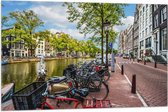Vlag - Rij Fiets Geparkeerd langs de Gracht in Amsterdam - 105x70 cm Foto op Polyester Vlag