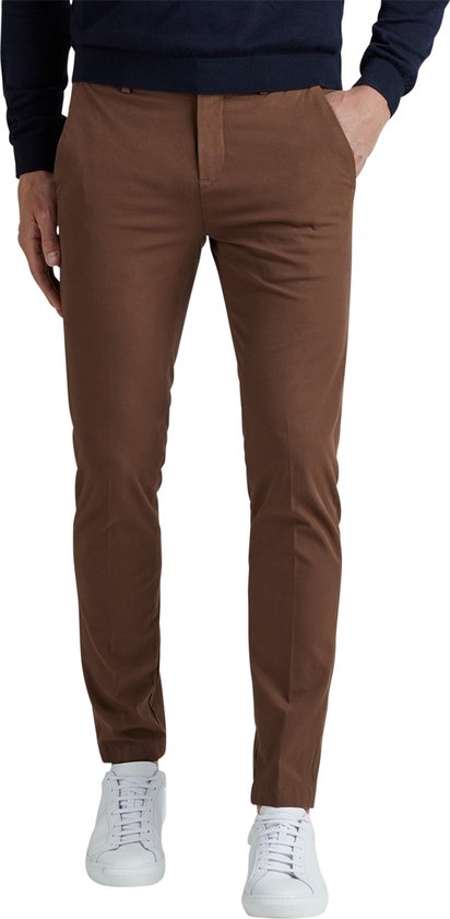 Voorkant van een man in een bruine Vanguard broek met donkerblauwe trui en witte sneakers.