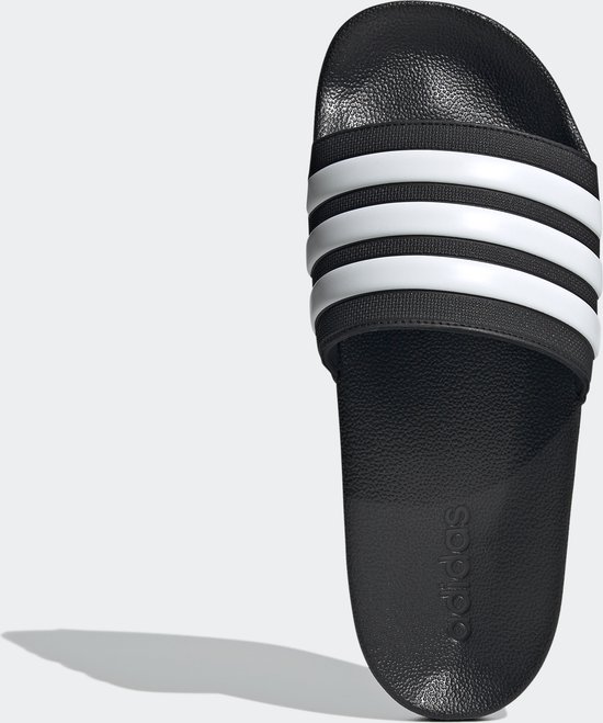 Tongs noires avec bandes Adidas blanches et logo.