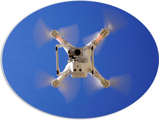 PVC Schuimplaat Ovaal - Onderaanzicht van Vliegende Drone onder Blauwe Lucht - 96x72 cm Foto op Ovaal (Met Ophangsysteem)