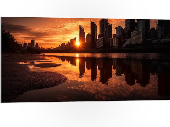 PVC Schuimplaat- Zon Verdwijnend tussen Wolkenkrabbers aan het Water - 100x50 cm Foto op PVC Schuimplaat