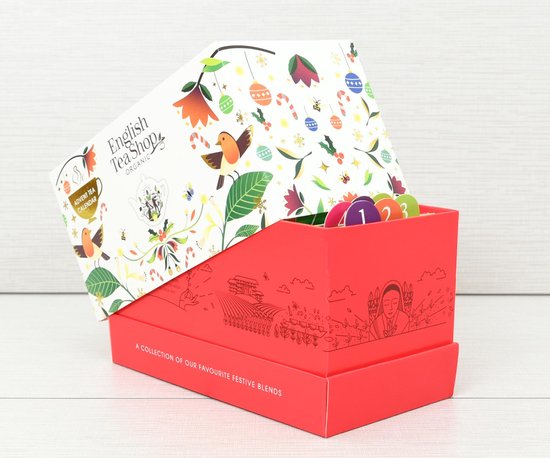 Rode opbergdoos met kerstillustraties en een wit deksel dat omhoog staat, gevuld met kleurrijke theezakjes.