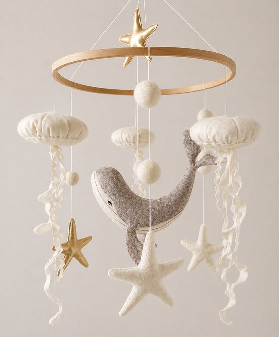 Houten baby mobiel met grijze walvis, witte kwallen, gouden en witte zeesterren en pompons.