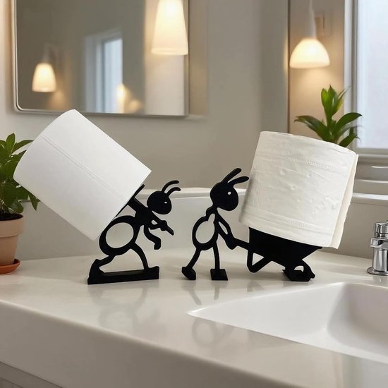 Zwarte metalen toiletrolhouders in de vorm van twee mieren, één duwt een kruiwagen met een rol, de ander draagt een rol op zijn rug.
