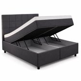 Donkergrijze boxspring met opbergruimte, matras opengeklapt.