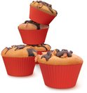 Vier rode siliconen muffinvormpjes, waarvan drie gestapeld en één met chocolade en walnoten bovenop.