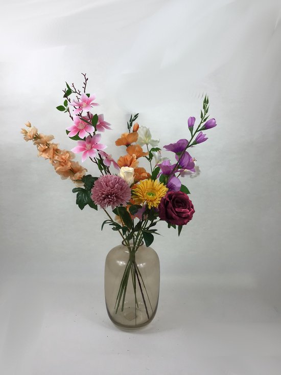 Boeket van kunstbloemen in diverse kleuren: roze, oranje, geel, paars, rood en wit in een glazen vaas.