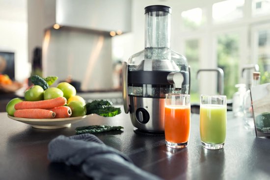 Philips sapcentrifuge in keuken met twee glazen sap, fruit en groenten ernaast.