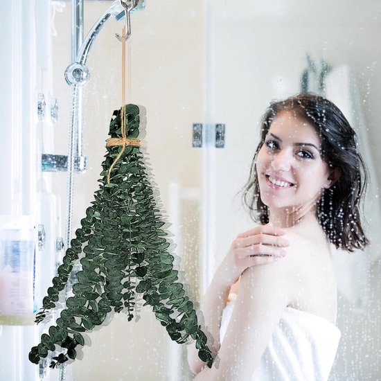 Vrouw onder de douche bij een hangende bundel gedroogde eucalyptus.
