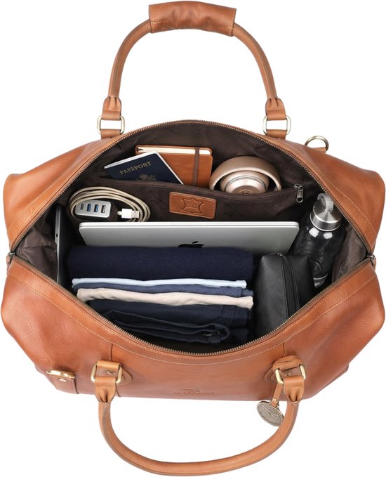 Open bruine leren reistas gevuld met kleding, laptop, paspoort en waterfles.