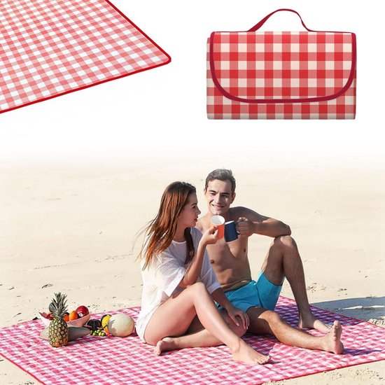 Een stel op het strand, zittend op een rood-wit geruit picknickkleed en genietend van een drankje. De deken is opgevouwen met handvat.